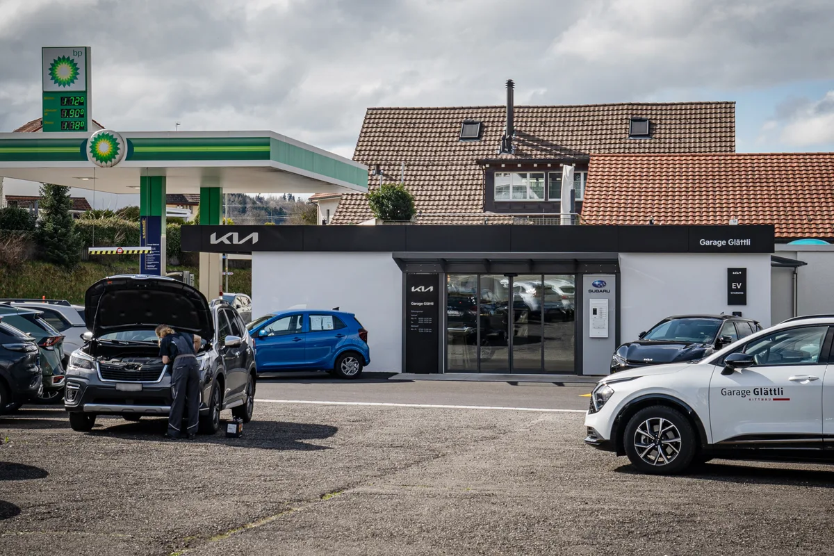 Die Garage Glättli AG in Hittnau von aussen: Man sieht links eine BP-Tankstelle, in der Mitte der Eingang in den Showroom und davor verschiedene Autos.
